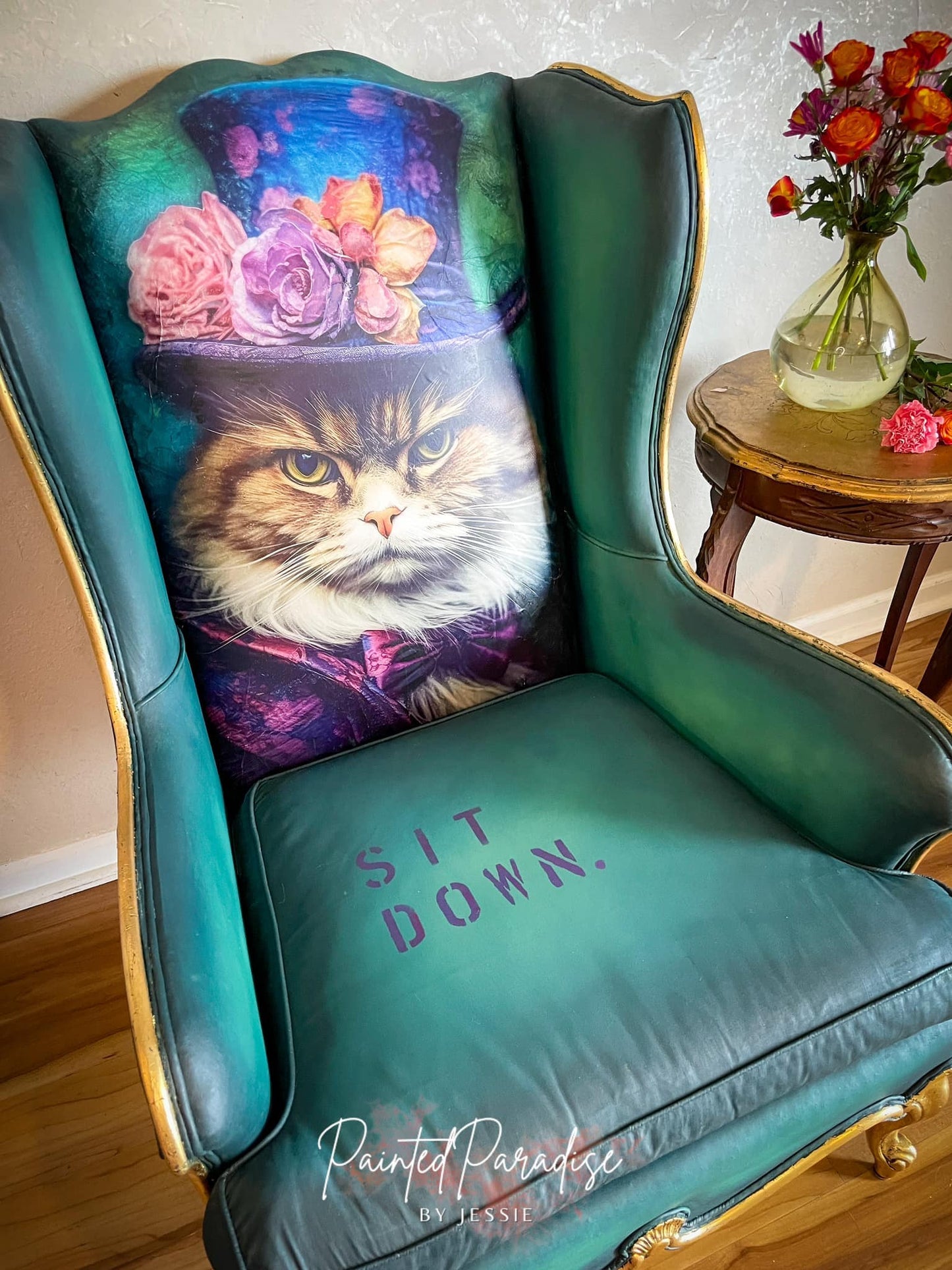 Painted wingback chair using Sour Puss the grumpy cat with a hat and the words sit down are painted on the seat.